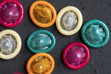 Güvenli seks kavramı. Tablo üzerinde çeşitli renkli prezervatif üstten görünüm