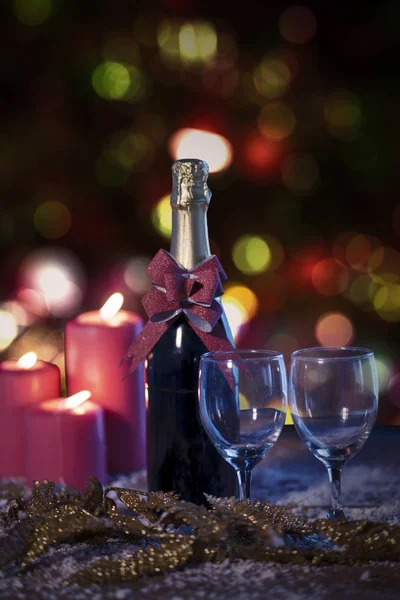 Two Glasses Champagne Bottle Red Candles Snow Blurred Christmas Light — Stock Photo, Image