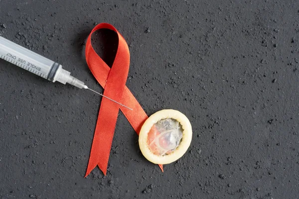 Closeup World Aids Awareness Day Ribbon Condom Syringe Black Background — Stock Photo, Image