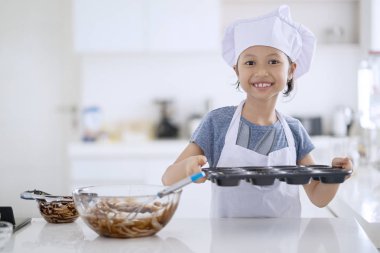 Tanımlama bilgisi ve mutfakta evde pişirme için hazır hale getirmek için bir kalıp çikolata hamur ile tutarak sevimli küçük kız portresi