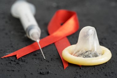 Siyah Masa üzerinde enjeksiyonu ve kırmızı kurdele prezervatif ile yakından
