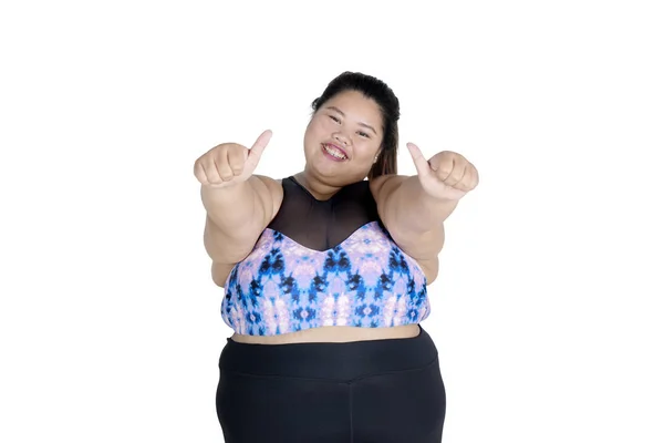 照片的快乐肥胖妇女穿着运动服 同时显示大拇指在相机 查出的白色背景 — 图库照片