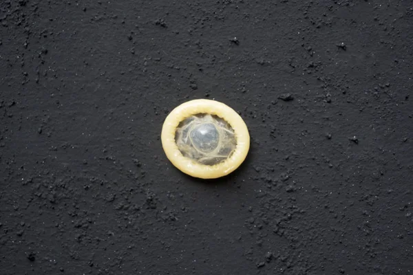 Pendekatan Kondom Kuning Pada Latar Belakang Hitam Konsep Seks Yang — Stok Foto