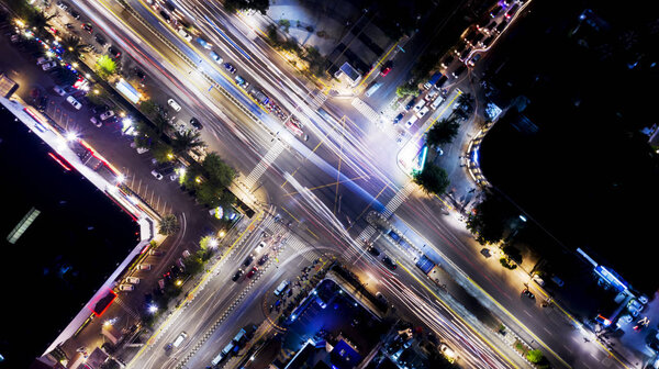 Aerial view of beautiful light trails on the crossroads at night time in Jakarta city 