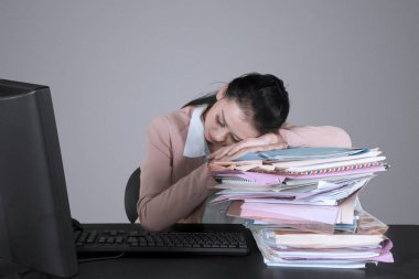 Yorgun işkadını bilgisayarla çalışırken belgeleri yığını üzerinde uyku resmini