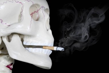 İnsan kafatası koyu arka planda Yakılan sigara ile kapatın. Hiçbir tütün gün kavramı