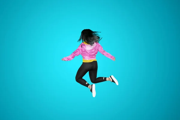 Задний Вид Современную Танцовщицу Прыгающую Студии Синем Фоне — стоковое фото