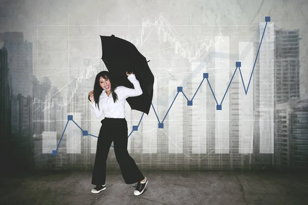 金融の成長チャート近く踊りながら傘を持って幸せな実業家の画像 — ストック写真