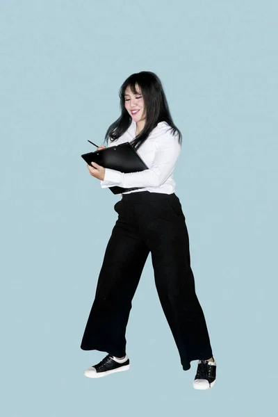スタジオに立ちながらクリップボードの操作はかなりビジネスの女性の完全な長さ — ストック写真