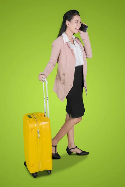 在演播室里拿着行李箱时 一名女企业家用手机说话的全长 — 图库照片