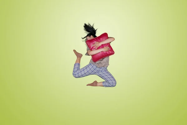 Imagem Uma Jovem Mulher Abraçando Travesseiro Vermelho Enquanto Saltava Estúdio — Fotografia de Stock