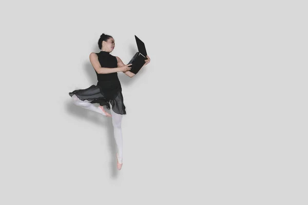 Obraz Młodego Kobiece Baleriny Trzymając Laptop Podczas Wykonywania Ćwiczeń Skok — Zdjęcie stockowe