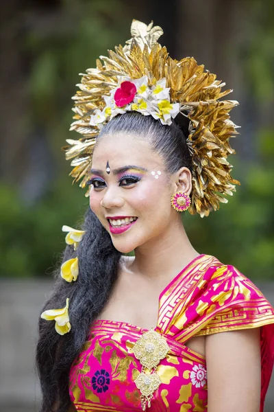 一位传统巴厘岛舞蹈家坐在户外对着镜头微笑的肖像 — 图库照片