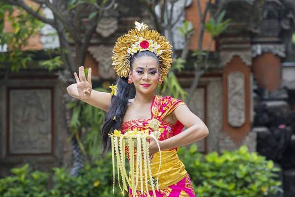 Picture of Asian female dancer wearing traditional Balinese dress while performing Pendet dances at outdoor