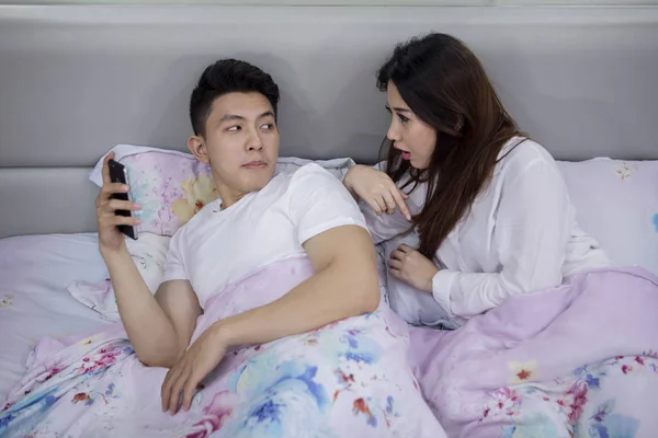 Asian Woman Watching Her Husband Phone While Lying Together Bed — Stock Photo, Image