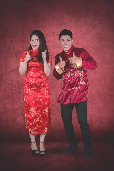 Mladý Čínský Pár Šatech Cheongsam Vykazovala Palce Červeném Pozadí Celé — Stock fotografie