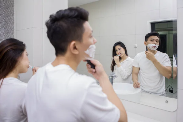 Foto Van Jongeman Scheren Van Zijn Baard Zijn Vrouw Tandenpoetsen — Stockfoto