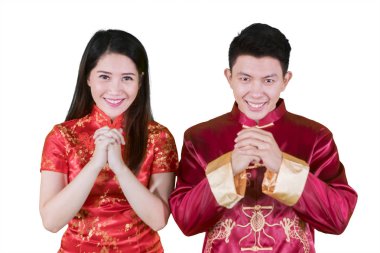 Asya çift beyaz arka plan üzerinde izole cheongsam elbise giyen süre mutlu Çin yeni yılı kutladı