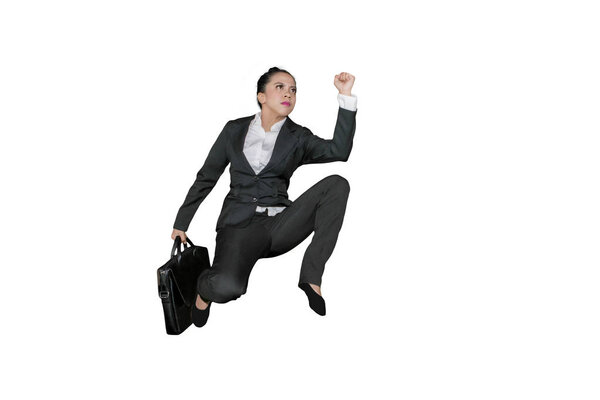 Low angle view of female manager carrying a suitcase while sprinting on the studio, isolated on white background