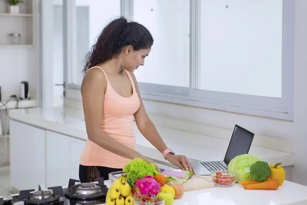 Photo Jeune Femme Cuisinant Des Légumes Dans Cuisine Tout Regardant — Photo