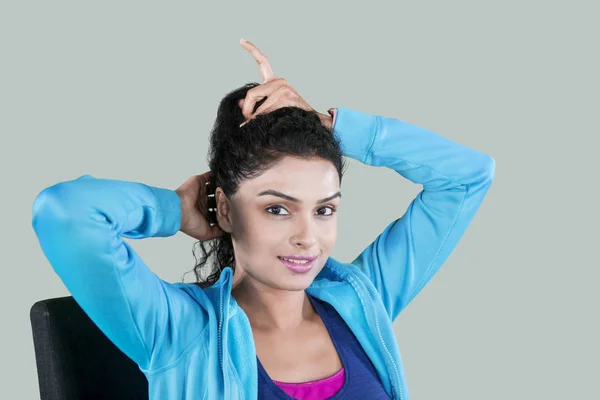 Imagem Jovem Mulher Sorrindo Para Câmera Enquanto Amarra Seu Cabelo — Fotografia de Stock