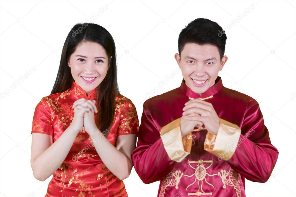 Asian couple congratulates happy Chinese new year while wearing cheongsam dress, isolated on white background
