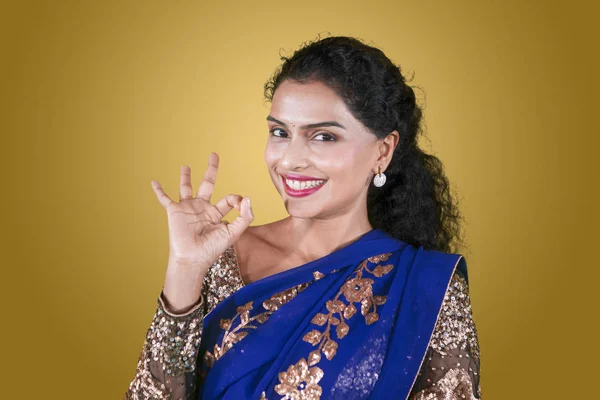 迷人的印度妇女显示好标志手势 而微笑着 穿着蓝色的萨里衣服在演播室 — 图库照片