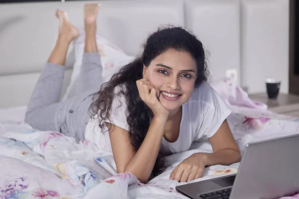 Hermosa Mujer Sonriendo Cámara Mientras Está Acostada Con Portátil Cama —  Fotos de Stock