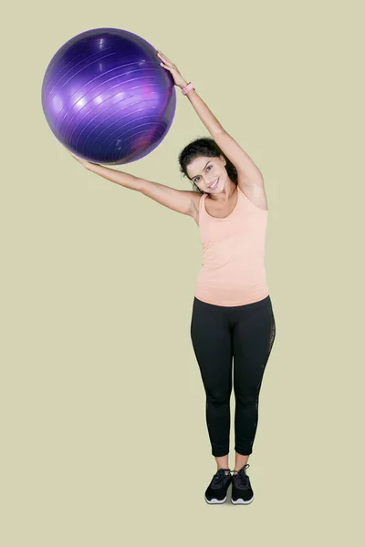 Mulher Jovem Saudável Exercitando Enquanto Segurando Bola Pilates Sorrindo Para — Fotografia de Stock