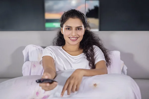 美丽的年轻亚洲女人坐在卧室里一边看电视 晚上拿着遥控器 — 图库照片