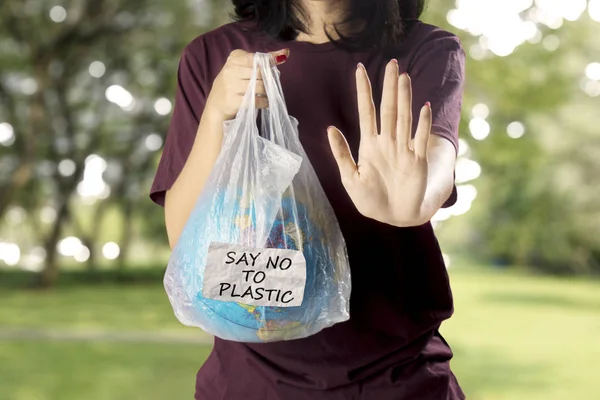 Młoda Kobieta Trzymającego Kulę Ziemską Plastikowej Torbie Pokazując Gest Ręce — Zdjęcie stockowe