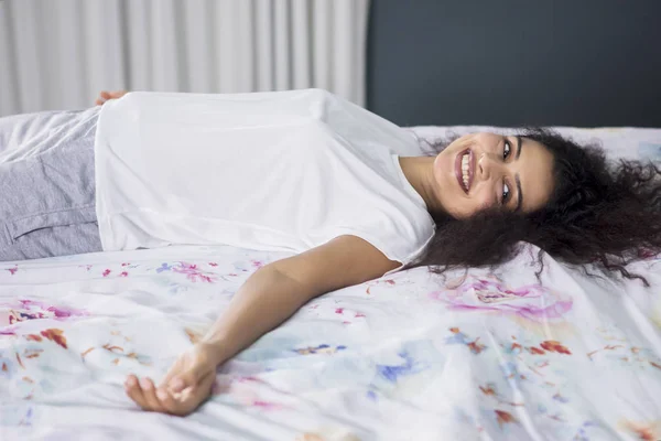 Immagine Donna Capelli Ricci Sorridente Alla Fotocamera Mentre Sdraiato Sul — Foto Stock