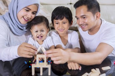 Mutlu aile oturma odasında otururken bir rüya ev inşa için tahta bloklarla oynama görüntü