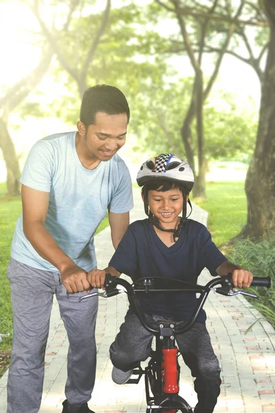 Retrato Jovem Que Guia Filho Andar Bicicleta Parque Tiro Hora — Fotografia de Stock