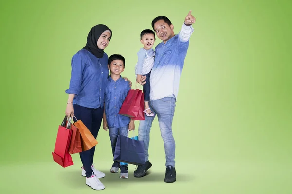 Imagem Família Feliz Fazendo Compras Juntos Enquanto Apontando Algo Estúdio — Fotografia de Stock