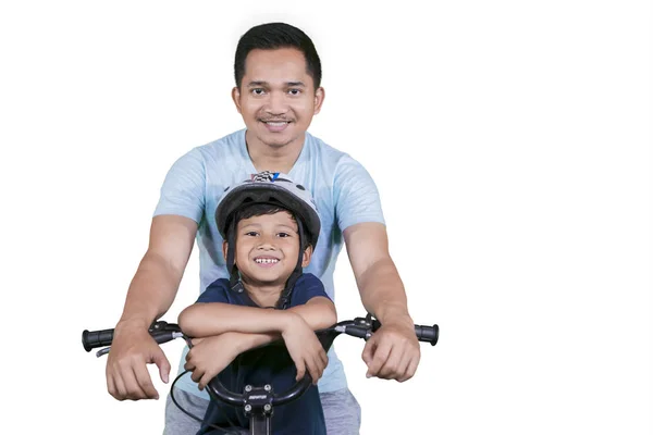 快乐的父亲看着镜头 而骑自行车与他的儿子在演播室 孤立在白色背景 — 图库照片