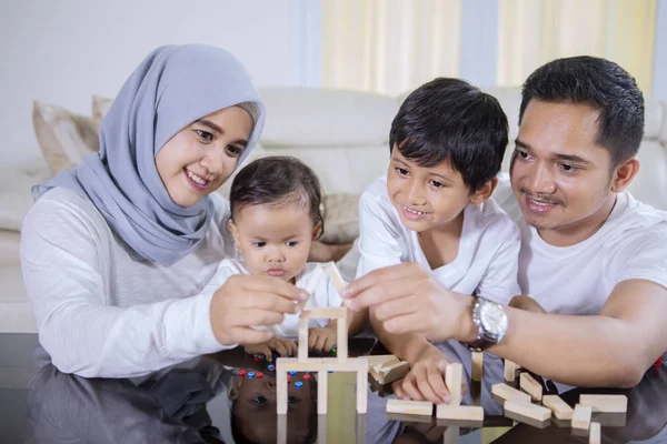 穆斯林家庭坐在客厅里 一起建造一个梦想中的木块房子的照片 — 图库照片