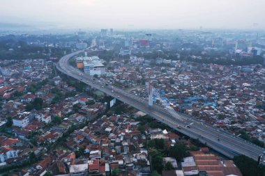 Bandung - Indonesia. January 03, 2019: Drone view of Bandung downtown with Pasupati overpass at misty morning clipart