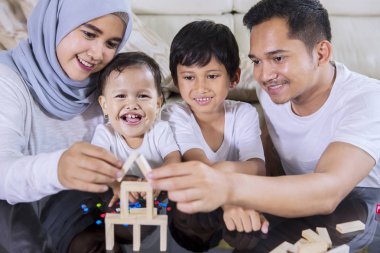 Mutlu aile oturma odasında otururken bir rüya ev inşa için tahta bloklarla oynama görüntü