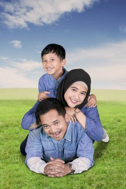 Müslüman aile birlikte çayırda yalan sırasında kameraya gülümseyen portresi