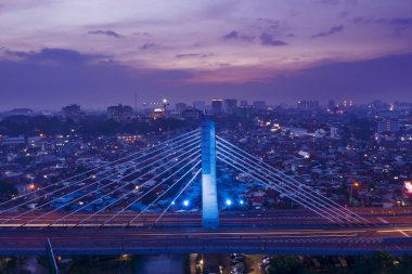 Bandung - Indonesia. January 03, 2019: Drone view of Pasupati overpass and crowded residential houses at dusk time in Bandung downtown clipart