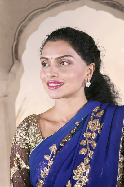 Picture of a beautiful Indian woman looks pensive while wearing saree clothes