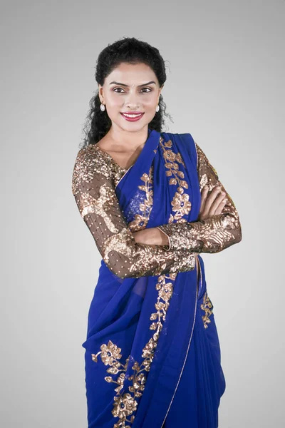 Portrait of confident Indian woman wearing a blue saree dress while standing in the studio