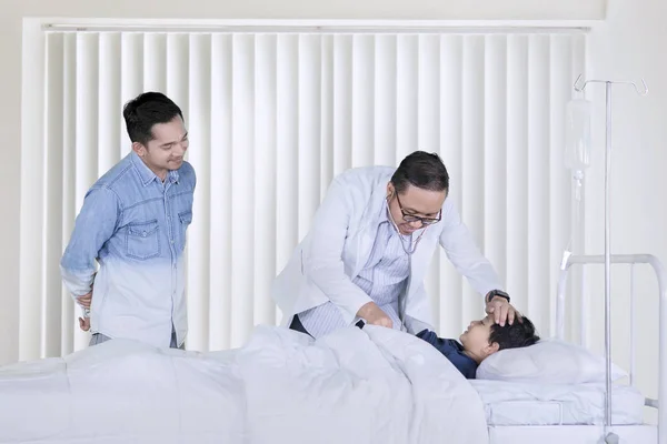 Imagem Pediatra Masculino Examinando Seu Pequeno Paciente Usando Estetoscópio Enquanto — Fotografia de Stock