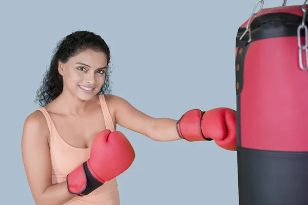Picture Pretty Girl Smiling Camera While Punching Boxing Bag Studio — Stock Photo, Image