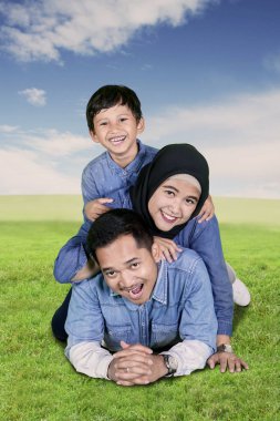 Küçük çocuk ailesi ile birlikte parkta yalan sırasında eğlenmek portresi 