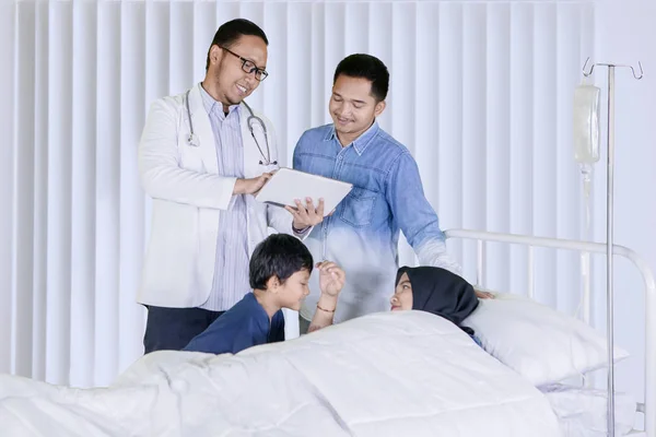 Врач Мужчина Показывает Пациенту Своей Семьи Цифровую Таблетку Объясняя Медицинский — стоковое фото