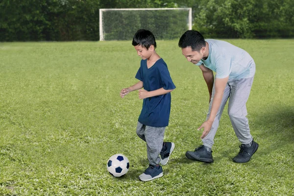 Bild Liten Pojke Ser Lycklig Medan Spelar Fotboll Med Sin — Stockfoto