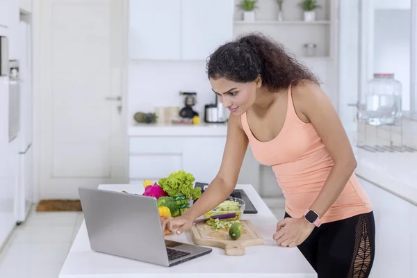 Sidovy Söt Flicka Som Använder Bärbar Dator Medan Förbereder Sallad — Stockfoto