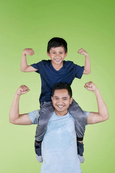 Retrato Joven Apoyando Hijo Mientras Muestra Sus Bíceps Estudio Con —  Fotos de Stock